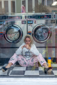 Woman sits in front of washing machine in a launderette in San Francisco Woman sits in front of washing machine in a launderette in San Francisco